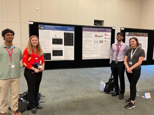 2 students on each side of poster and poster presentation