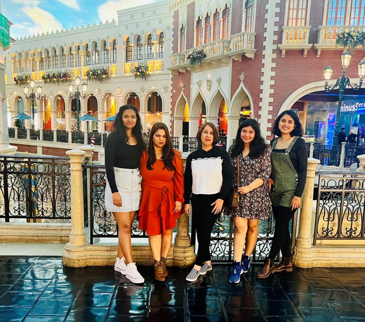 Five lab members stand in a line, posed for a photo outside in front of a fancy building