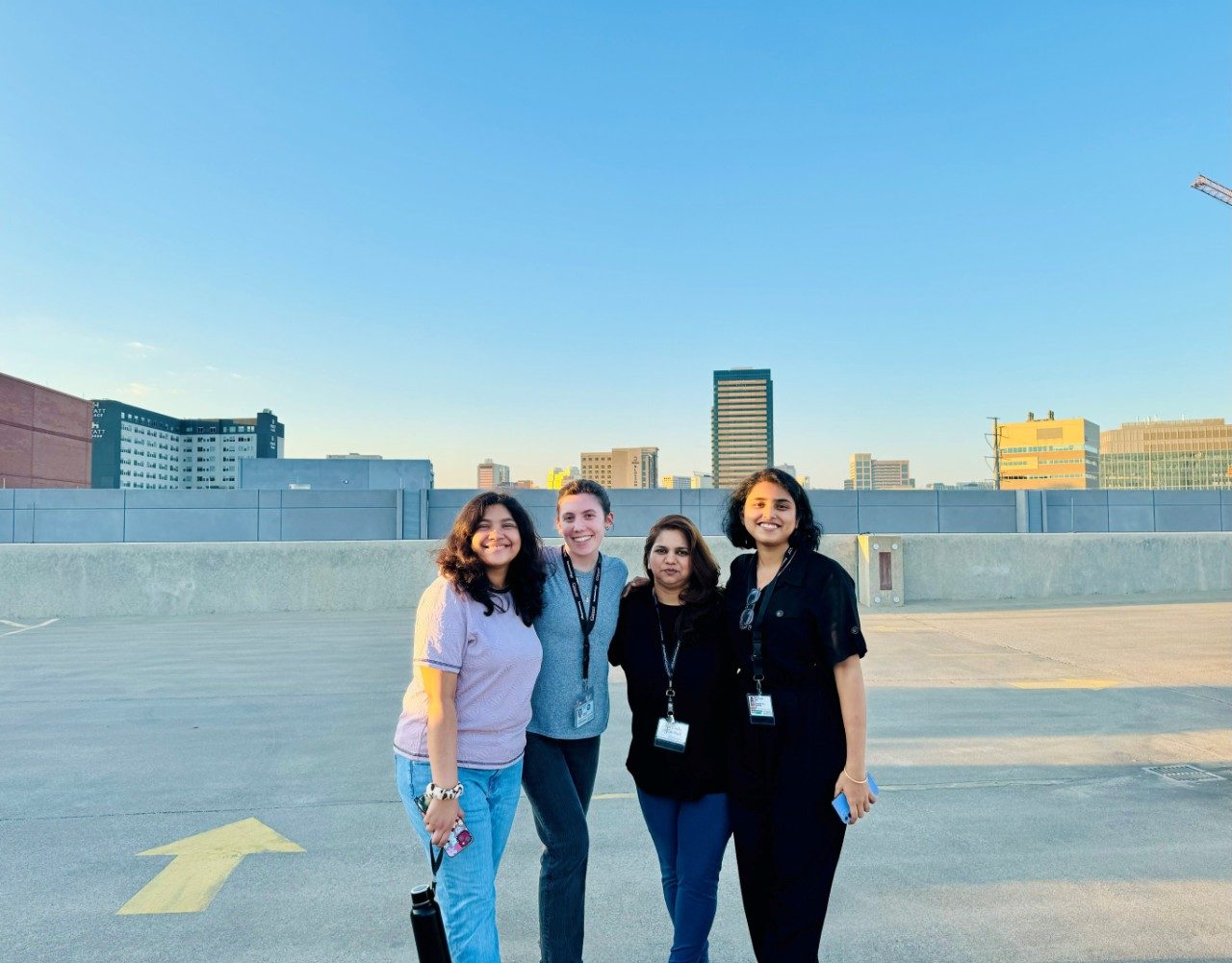Four lab members lined up for a photo on the roof of a parking garage