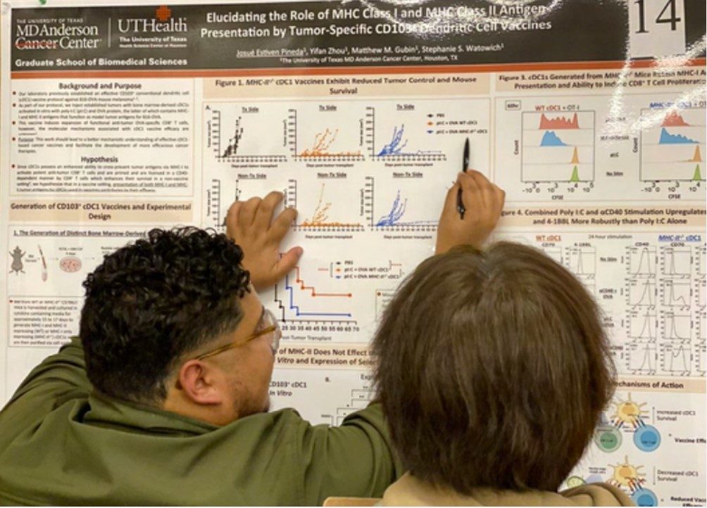 A person usese a pen and fingers to point out results on a poster to someone else