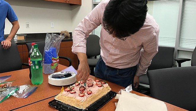 Jian Hu cutting birthday cake