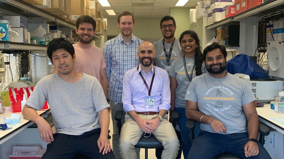 The Huse lab poses for a group photo in between benches