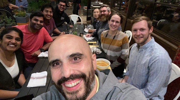 Huse lab members take a selfie around a table