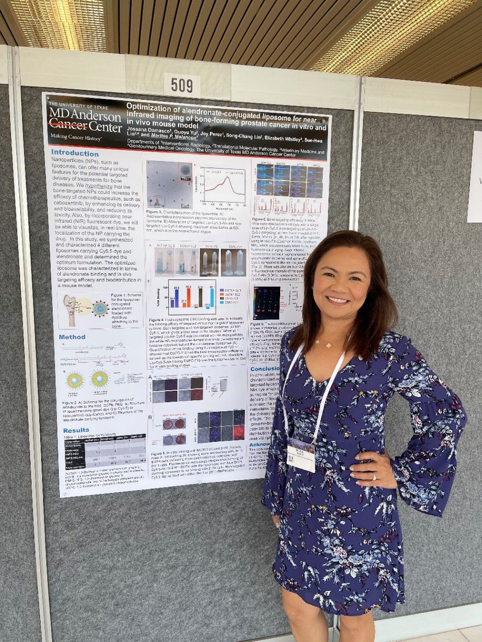 A woman stands in front of a poster