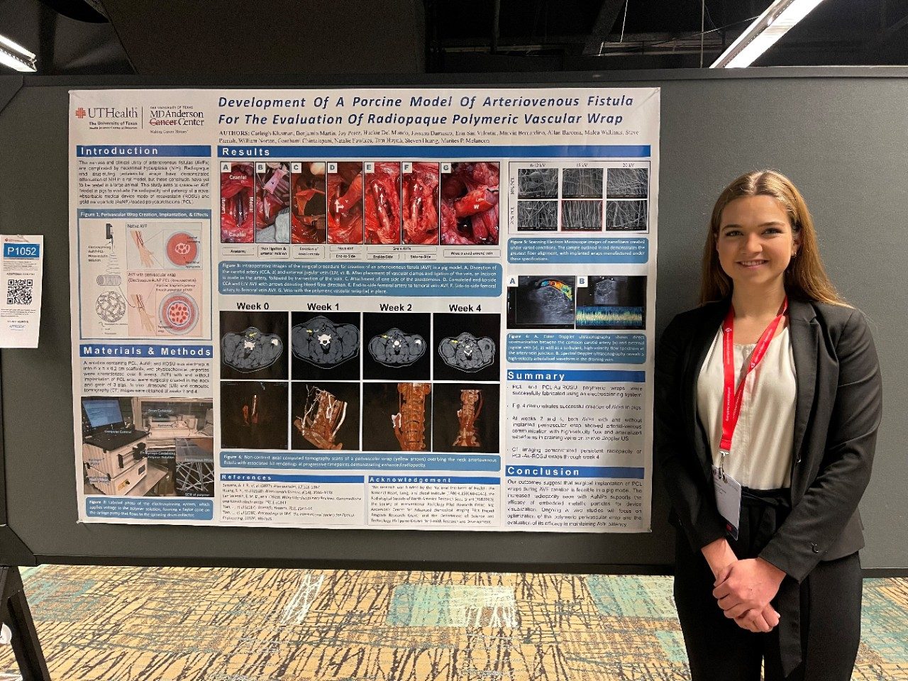 A woman stands in front of a poster