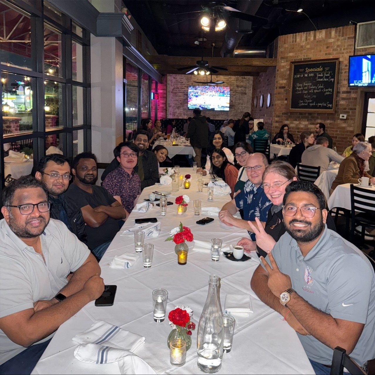 People at a long, rectangular table with a white tablecloth at a restaurant
