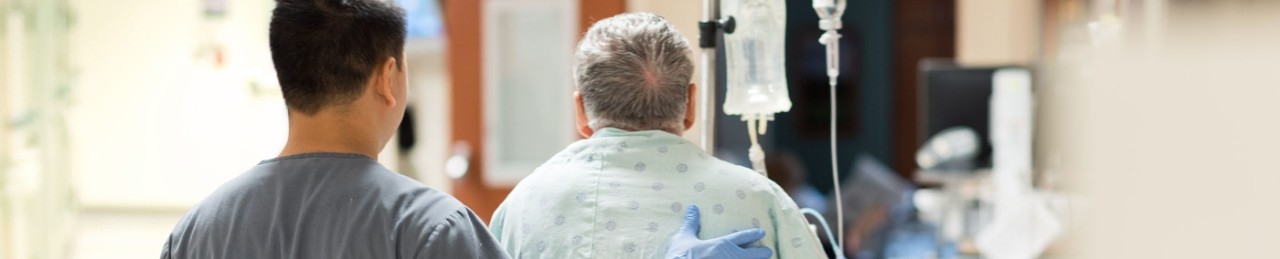 Nurse walking patient down a hallway